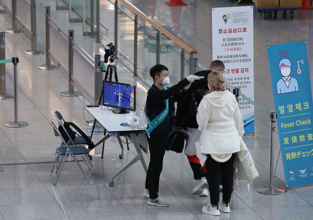 24일 인천국제공항 1터미널 출국장에서 출국하는 외국인이 발열 체크를 받고 있다. [연합뉴스]