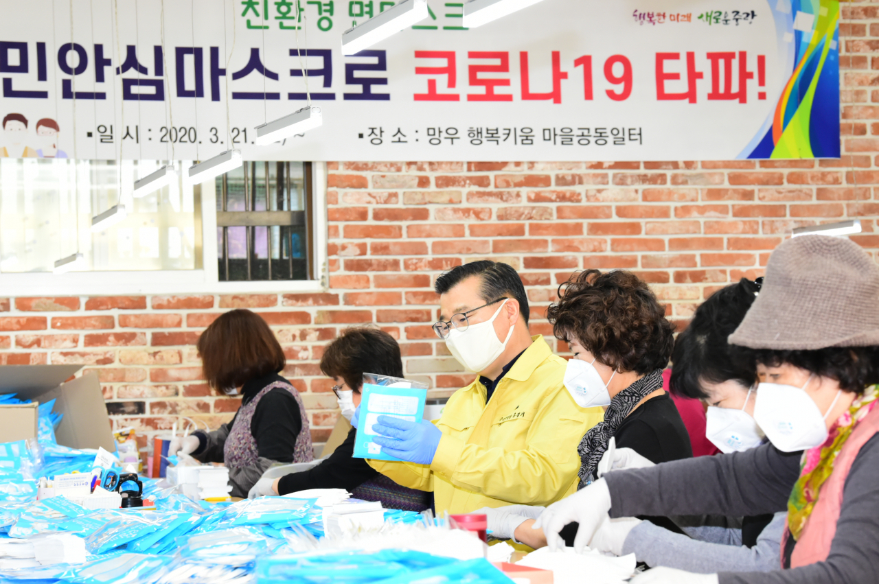 류경기 중랑구청장이 망우 행복키움 마을공동일터를 방문해 국민안심마스크 포장 작업을 하고 있다. [중랑구 제공]