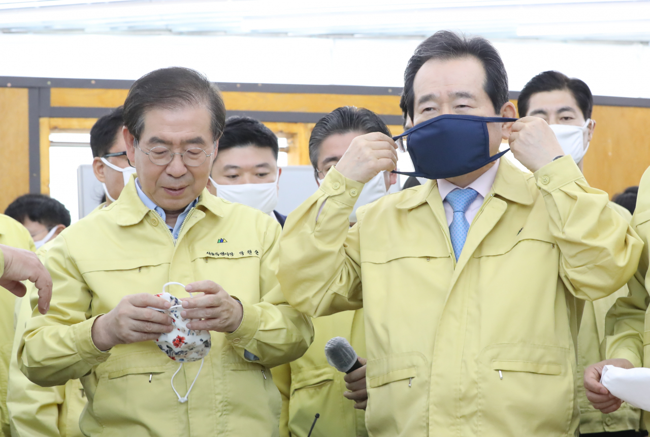 정세균 (오른쪽)국무총리와 박원순 서울시장이 25일 서울 용산구 서계동에 위치한 봉제공장 '코워킹팩토리'봉제공장을 방문, 필터 교체형 마스크를 쓰고 있다. [연합]