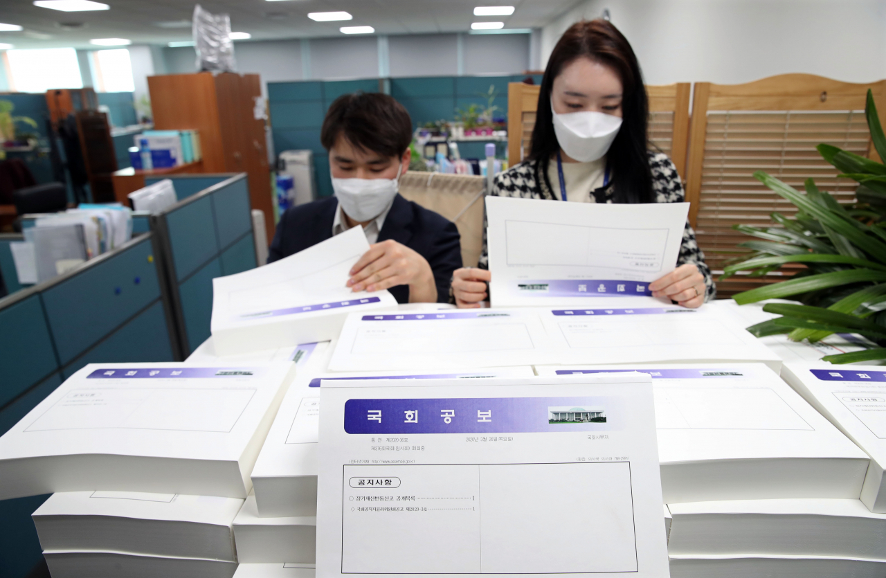 25일 국회에서 국회사무처 관계자들이 관보를 통해 공개된 재산공개 대상자 1865명의 2020년 정기 재산변동사항 신고내역을 살펴보고 있다. [연합]