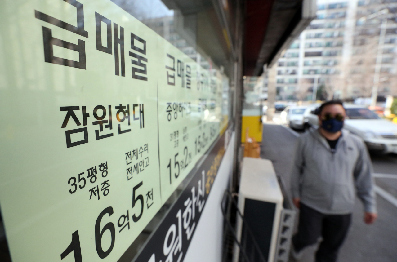 24일 서울 서초구 한 부동산 공인중개업소 앞을 시민이 지나고 있다.[연합]