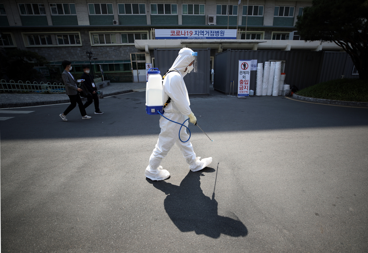 지난 25일 대구시 중구 계명대학교 대구동산병원에서 한 관계자가 방역작업을 하고 있다. [연합]