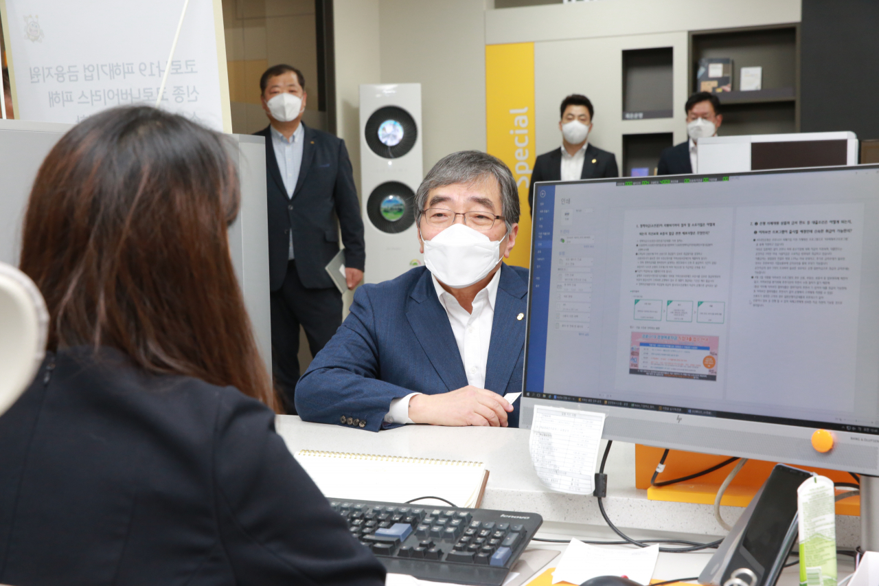 윤석헌 금융감독원장이 26일 서울 동작구 KB국민은행 사당동지점을 방문해 창구 직원과 이야기를 나누고 있다.[연합]