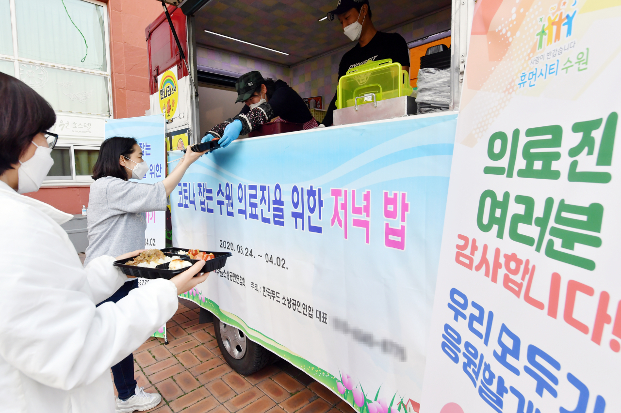 수원시 푸드트럭소상공인연합회가 수원호스텔을 이용하는 의료진에게 식사를 제공하고 있다. [수원시 제공]
