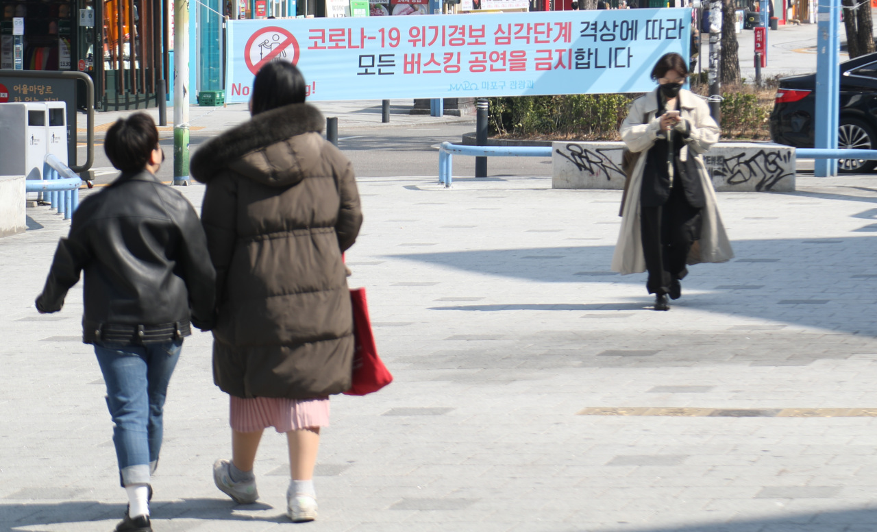 A banner that says all busking performances are banned due to the raised virus alert is seen in the Hongdae area in western Seoul on March 8. (Yonhap)