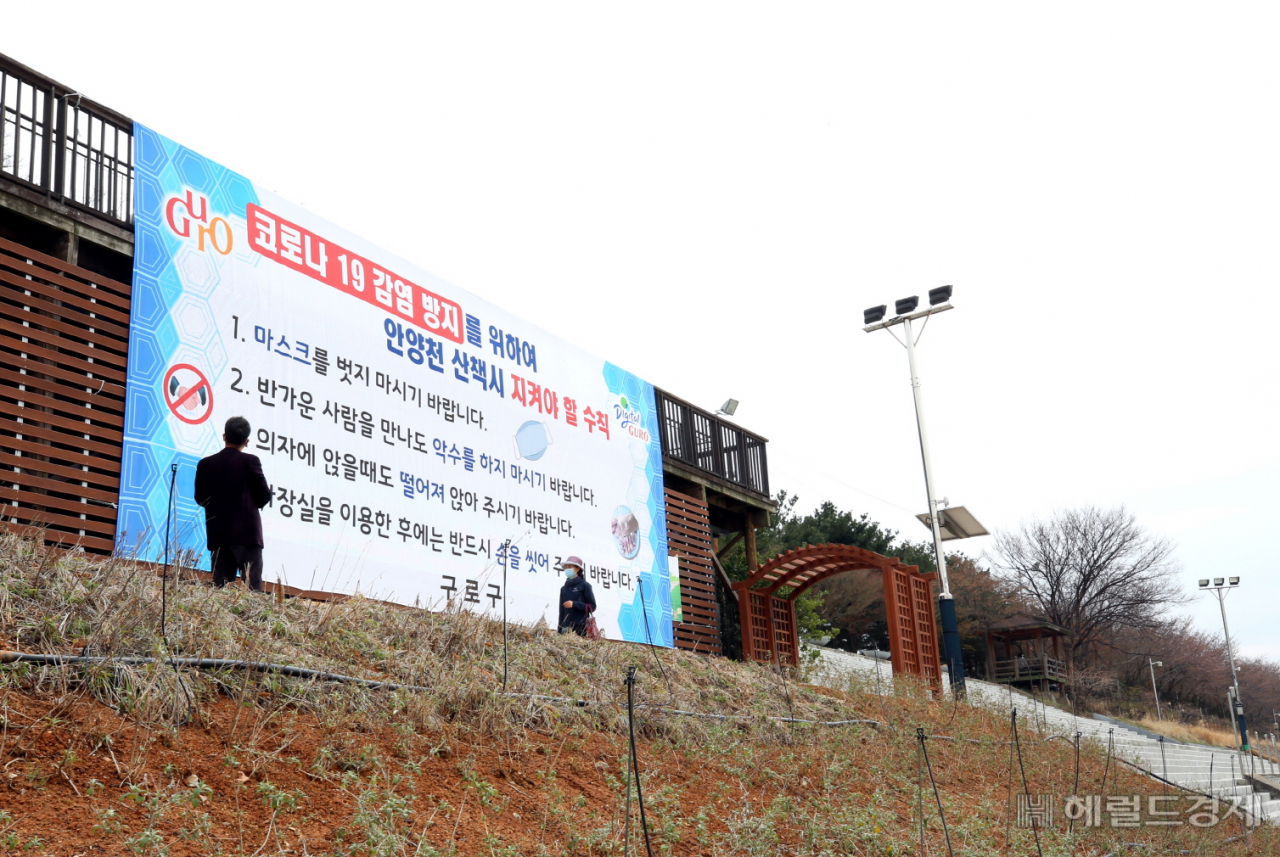 안양천변에 산책시 지켜야 할 코로나19 예방수칙 안내문이 걸려 있다. [구로구 제공]