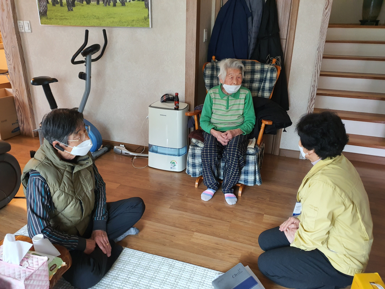 신종 코로나바이러스 감염증(코로나19) 국내 최고령 완치자인 황영주(97) 할머니(가운데)가 아들, 청도군 관계자와 마스크를 쓴 채 이야기를 하고 있다. 황 할머니는 지난 12일 코로나19 확진 판정을 받은 후 포항의료원에서 치료받은 뒤 지난 25일 완치 판정을 받고 집에 돌아왔다. [청도군 제공]