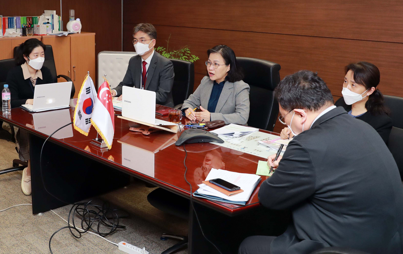 유명희(가운데) 산업통상자원부 통상교섭본부장이 26&sim;27일 정부서울청사에서 림 족 호이 아세안 사무총장, 찬 춘싱 싱가포르 통상장관, 리즈 트러스 영국 통상장관과 각각 화상회의를 진행, “기업인들의 입국을 예의적으로 허용하자”고 제안하고 있다.[산업통상자원부 제공]