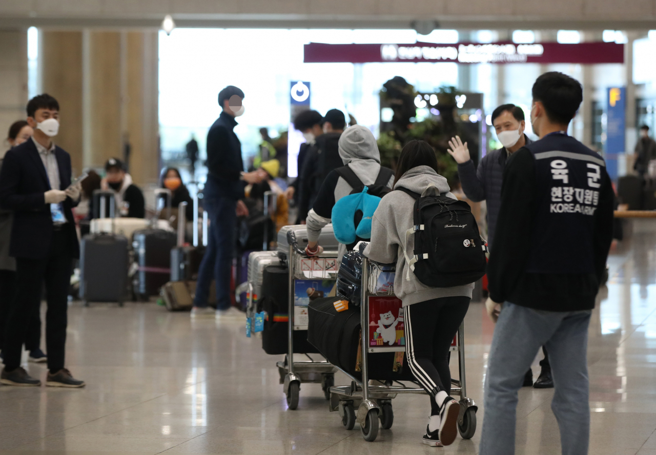 26일 오후 인천국제공항 1터미널에서 독일 프랑크푸르트발 여객기를 타고 귀국한 무증상 내국인들이 귀가하고 있다. 유럽발 입국자 가운데 내국인 무증상자는 자가격리를 시행하고, 관할 보건소에서 입국 후 3일 이내에 검사할 예정이다. [연합]