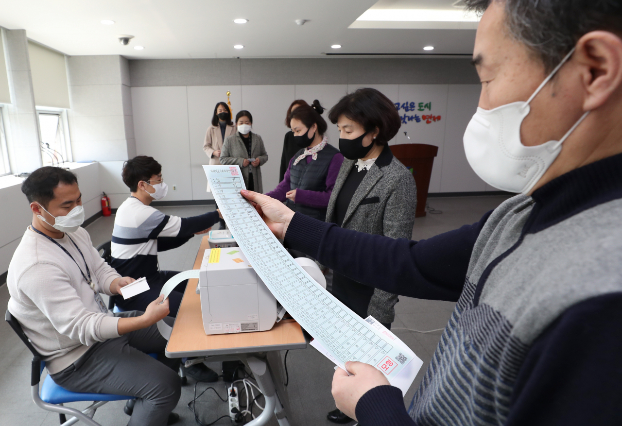 19일 오후 부산 연제구 연산 제2동 사전투표소(연제구청 대회의실) 모의 체험장에 마련된 '본인 확인 및 투표용지 교부석'에서 관계자들이 투표 진행 절차를 체험하고 있다. [연합]