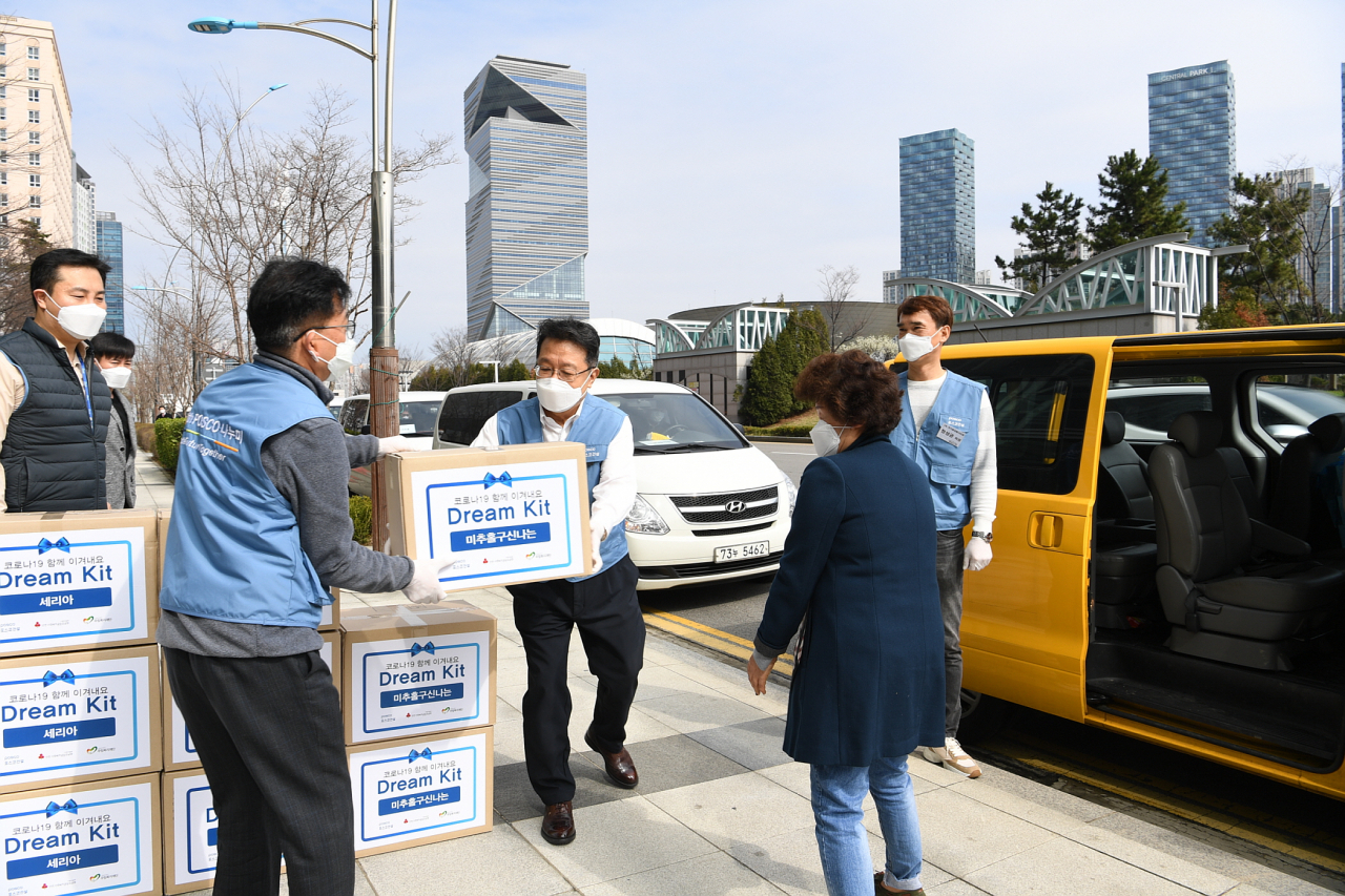 포스코건설 임직원들이 마스크와 손소독제, 도서 등을 담은 코로나 예방 키트를 전달하고 있다. [포스코건설]