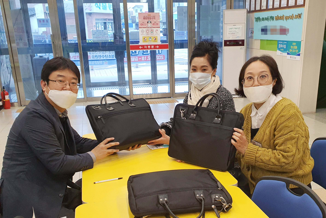 정무원 영진전문대 교수가 지난 27일 창녕에서 직장과 학업을 함께 하는 산업체위탁반 제자들을 만나 노트북을 전달하고 있다.[영진전문대 제공]