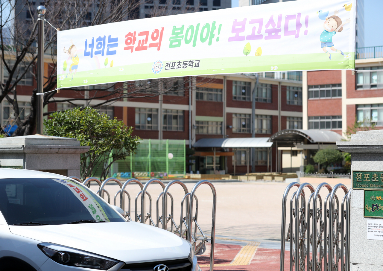 지난 25일 부산 전포동 전포초등학교 정문에 '너희는 학교의 봄이야 보고 싶다'라고 적힌 현수막이 걸려 있다. 전포초등학교는 코로나19로 개학이 연기돼 학교를 찾지 못하는 학생들에게 힘을 주기 위해 학교 3곳에 현수막을 부착했다. [연합]