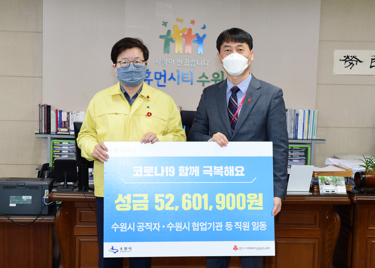 성금 전달 후 염태영 시장(왼쪽)과 이범열 모금사업2팀장이 함께하고 있다. [수원시 제공]