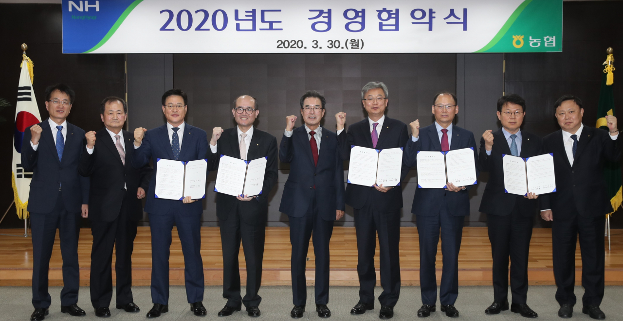 이성희 농협중앙회장(가운데)이 중앙회 및 경제·금융지주 대표 등 주요 임원들과 올해 경영협약을 체결한 뒤 차질없는 실천을 다짐하고 있다. [농협 제공]