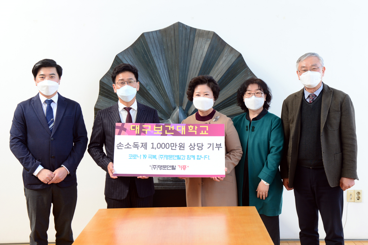 최일경 명문덴탈 대표(왼쪽 두번째)가 남성희 대구보건대 총장(가운데)에게 손소독제를 기증하고 있다.[대구보건대 제공]
