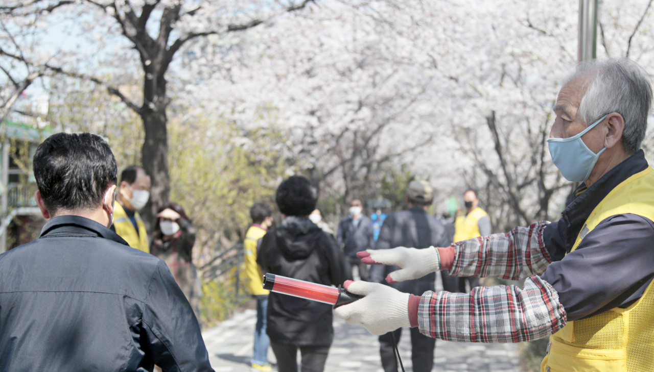 동작구는 코로나19 확산 차단을 위한 고강도 사회적 거리두기 실천에 따라 현장안내 요원들을 배치하고 주민들에게 벚꽃 나들이 자제와 보행시 2미터 거리두기 등을 계도하고 있다. [동작구 제공]