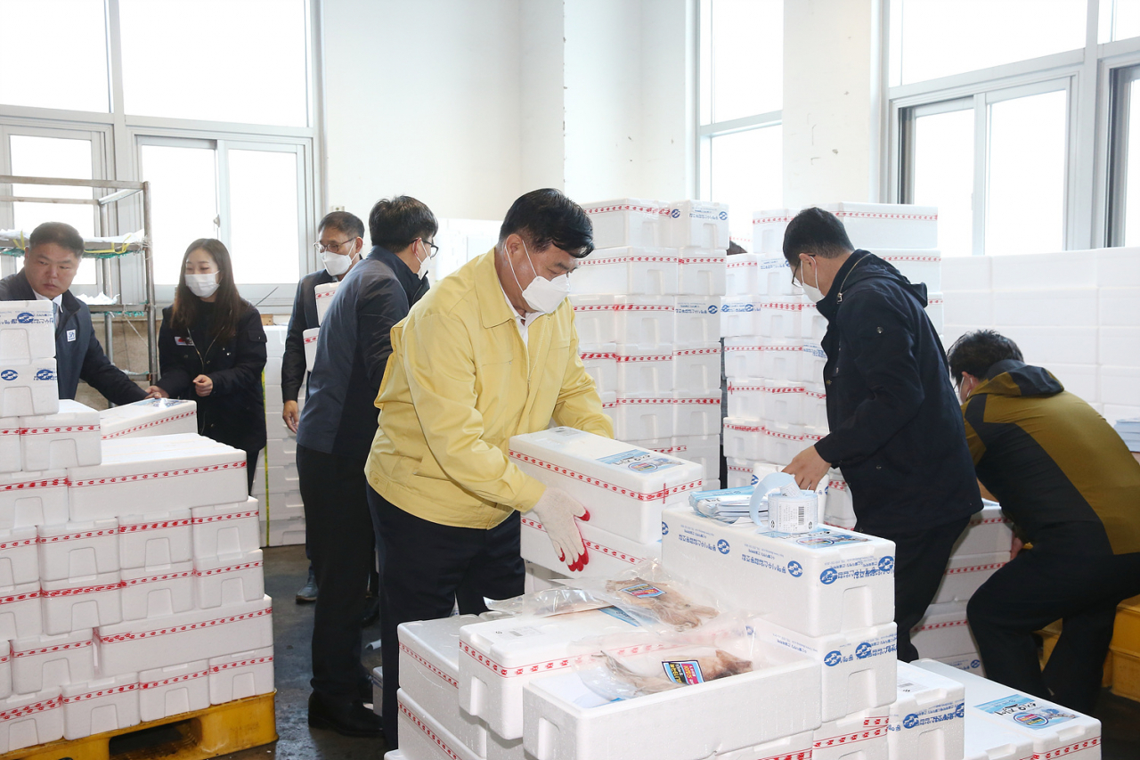 [지역경제 붕괴 막기, 자구책 안간힘] 코로나사태로 여행업 등 서비스업의 충격이 커지고 있는 가운데, 심규언 시장을 비롯한 동해시 공무원들이 민관 합동 오징어 팔아주기 일손을 돕고 있다.
