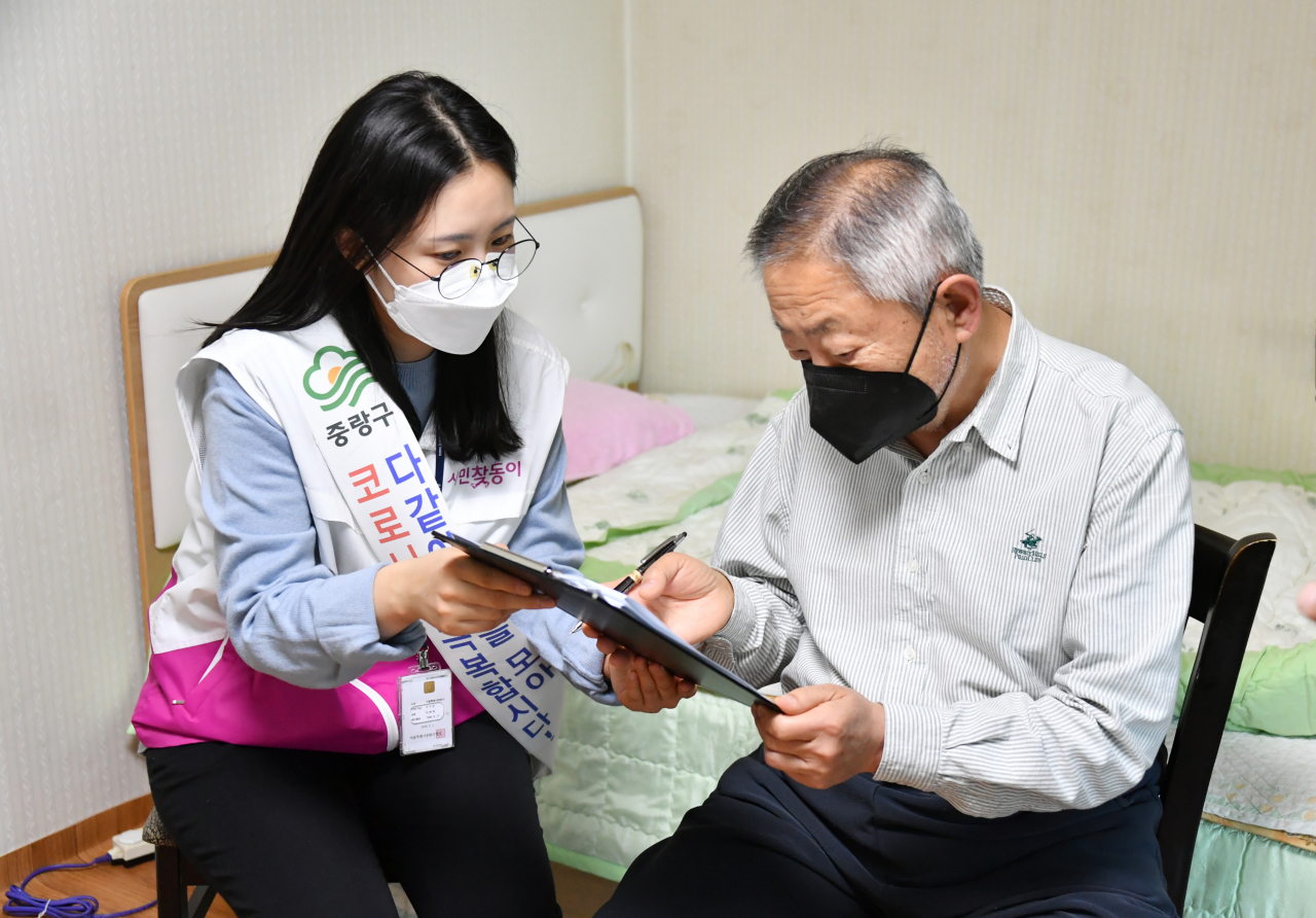 지난 30일 중랑구 신내2동 주민센터 직원이 거동이 불편한 어르신 가정에 직접 방문해 재난긴급생계비 지원 신청을 받고 있다. [중랑구 제공]