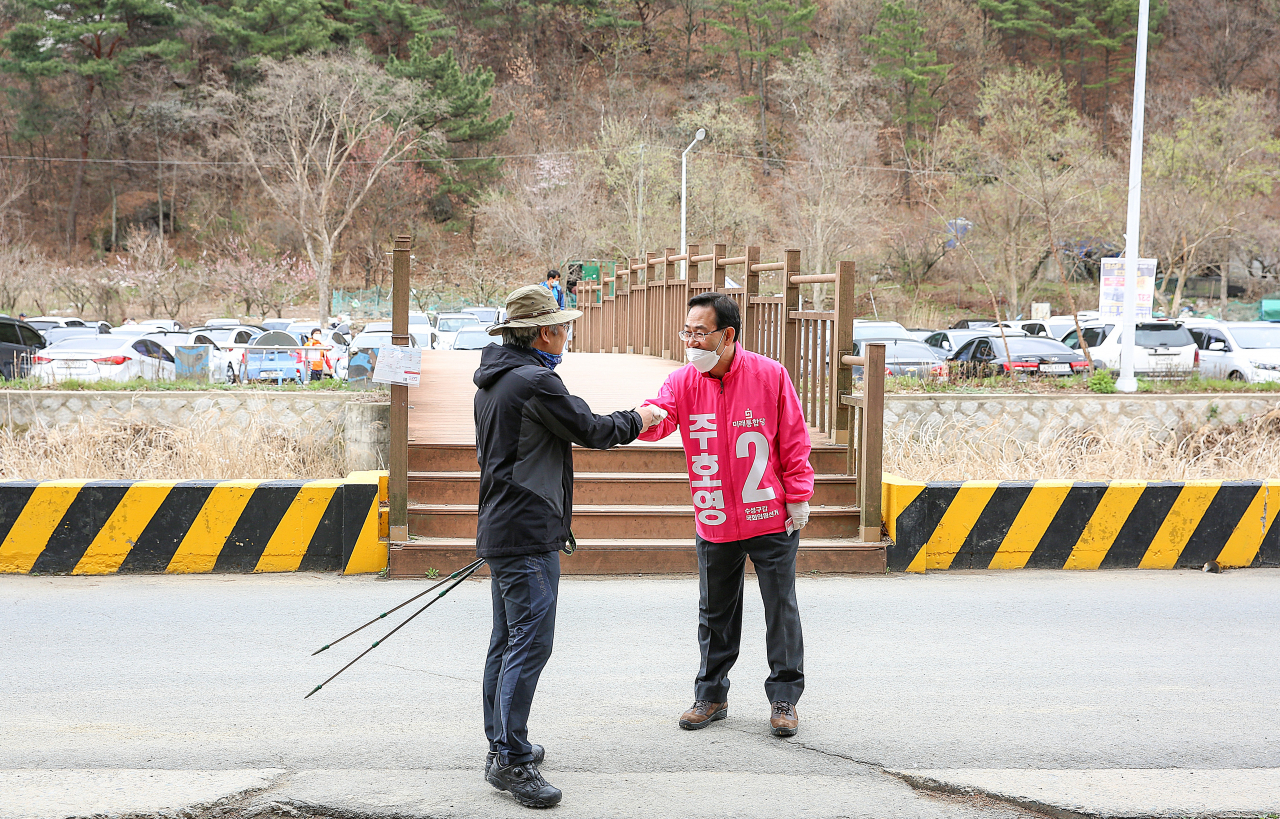 주호영 미래통합당 후보가 29일 오전 대구 수성구 욱수골 입구에서 산행 나온 시민과 인사를 나누고 있다. [연합]