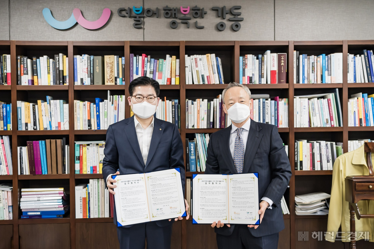 이정훈 강동구청장(왼쪽)과 김희준 메리디안 대표가 31일 업무협약서에 서명한 뒤 협약서를 들어보이고 있다. [강동구 제공]