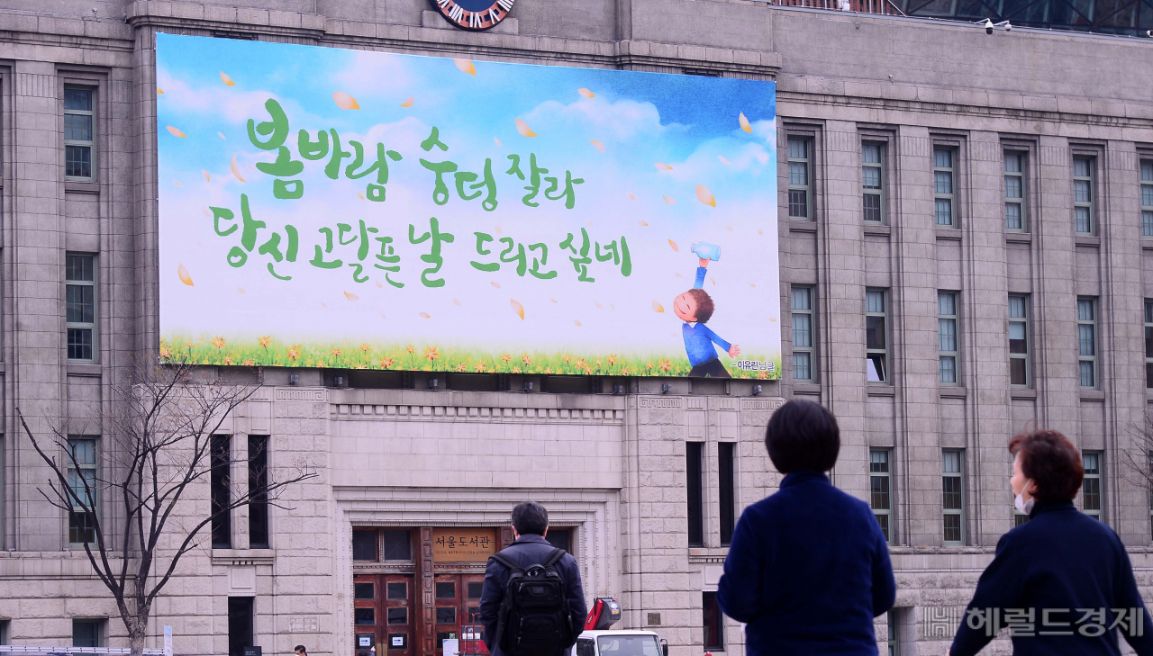 1일 서울 세종대로 서울광장 앞 서울도서관에 '봄바람 숭덩 잘라 당신 고달픈 날 드리고 싶네'라는 문구가 꿈새김판에 설치되어 있다. [이상섭 기자/babtong@heraldcorp.com]