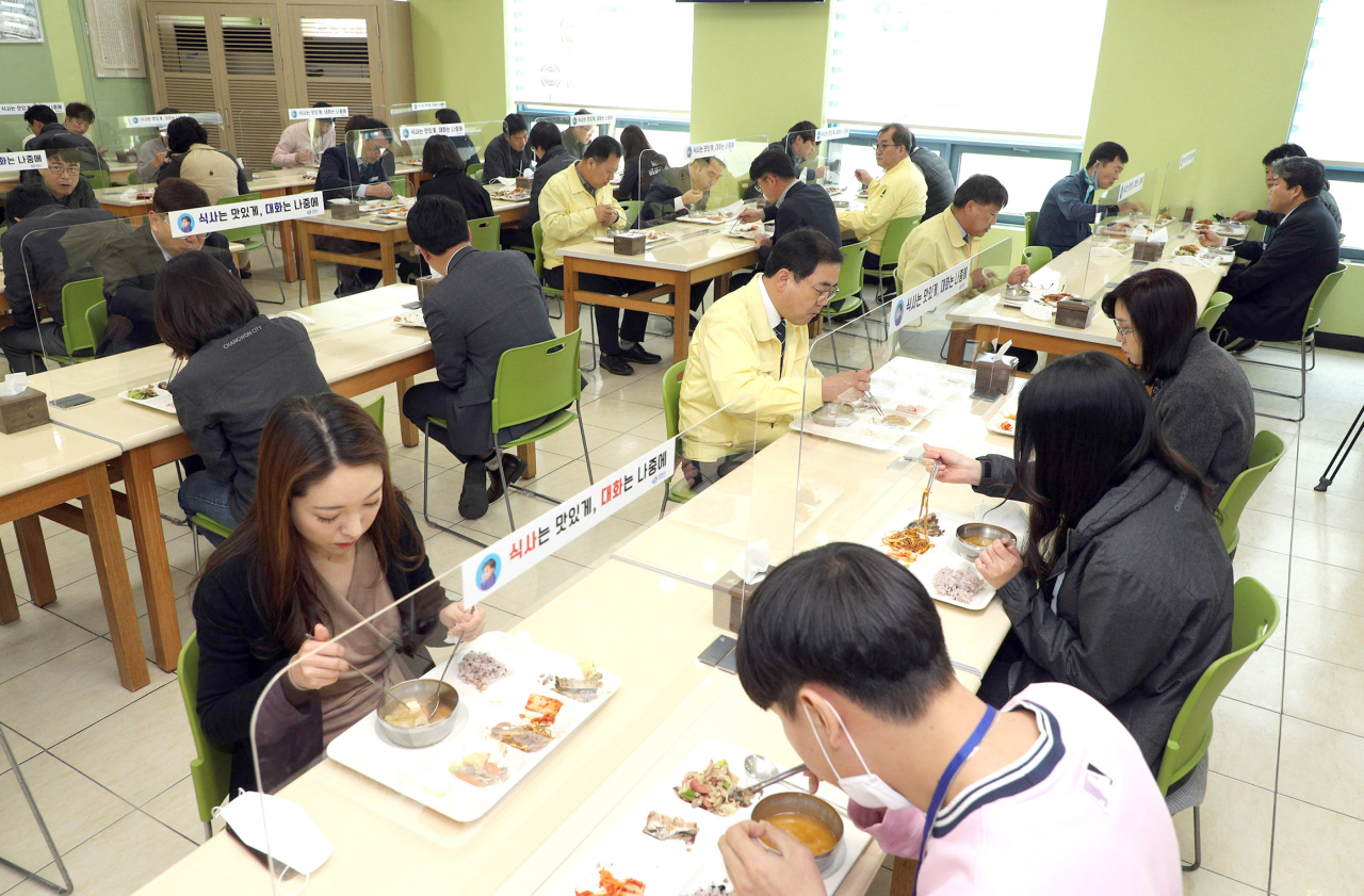 경남 창원시가 신종 코로나바이러스 감염증(코로나19) 확산을 막으려 시청 구내식당 식탁마다 칸막이를 설치했다. 허성무 시장 등 창원시 공무원들이 지난달 24일 구내식당에서 칸막이가 설치된 식탁에서 옆 사람과 거리를 둔 채 점심을 먹고 있다. [연합]