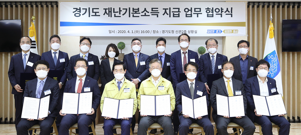 이재명 경기도지사와 안병용 경기도시장군수협의회 회장(의정부시장), 손병환 농협은행장 등 13개 은행과 카드사 대표들이 경기도 재난기본소득 지급 업무 협약을 체결하고 기념촬영을 하고 있다. [경기도 제공]