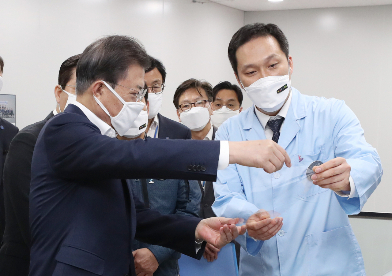 문재인 대통령이 1일 오전 불화폴리이미드 공장인 경북 구미시 코오롱인더스트리 구미사업장을 방문, 생산된 불화폴리이미드필름을 보고 있다. [연합]