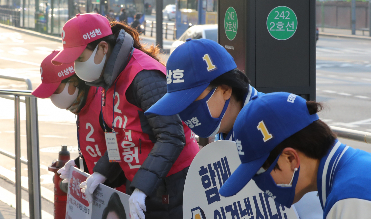21대 총선 선거운동이 시작된 2일 오전 서울 서대문구 북아현동 아현역 입구에서 더불어민주당과 미래통합당 운동원들이 마스크를 끼고 시민들에게 인사하고 있다. [연합]