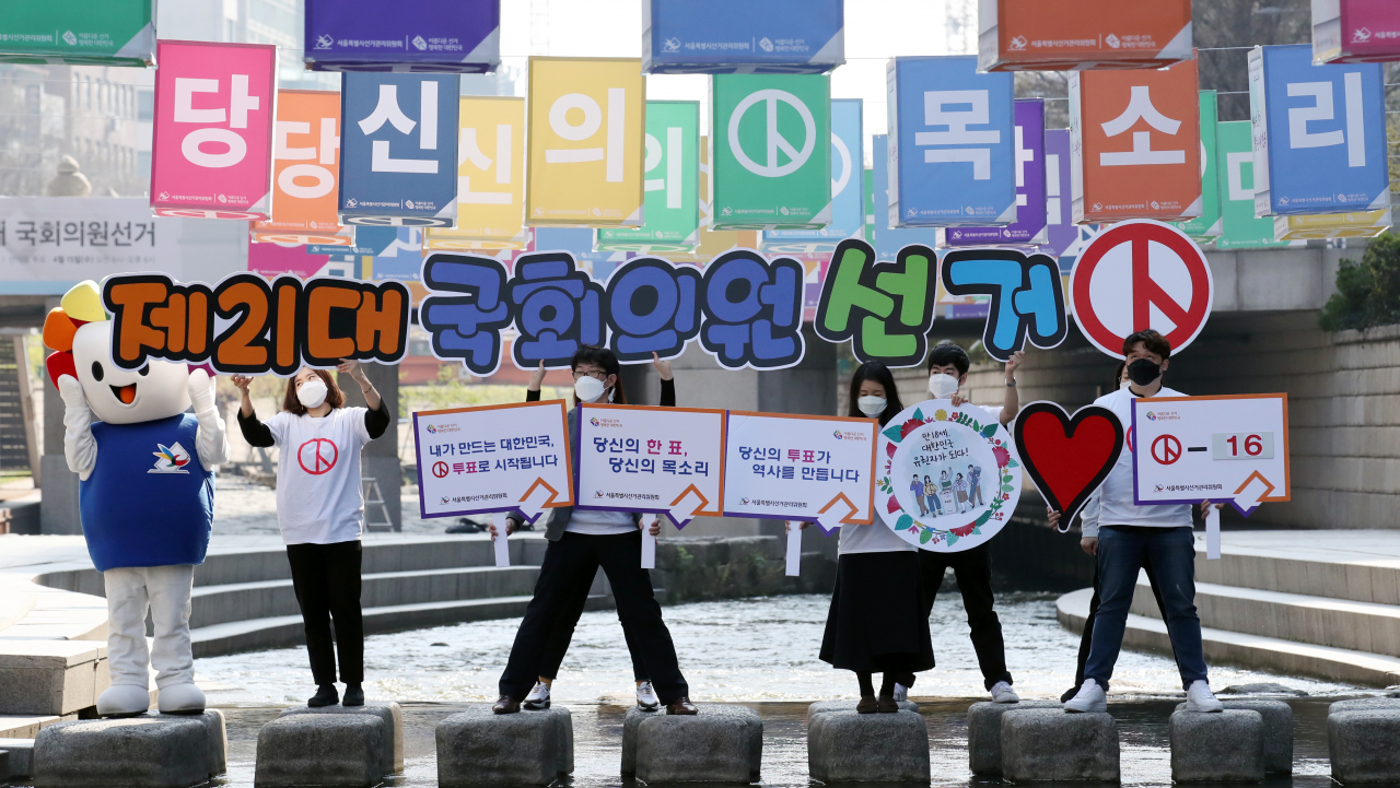 서울시 선거관리위원회 관계자들이 지난달 30일 오전 서울 중구 무교동 청계천 모전교 부근 징검다리에서 손팻말을 든 채 21대 총선 '4.15 아름다운 선거' 홍보를 하고 있다. [연합]