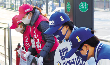 21대 총선 선거운동이 시작된 2일 오전 서울 서대문구 북아현동 아현역 입구에서 우상호 더불어민주당 서대문갑 후보 운동원들과 이성헌 미래통합당 서대문갑 후보 운동원들이 마스크를 끼고 시민들에게 인사하고 있다. [연합]