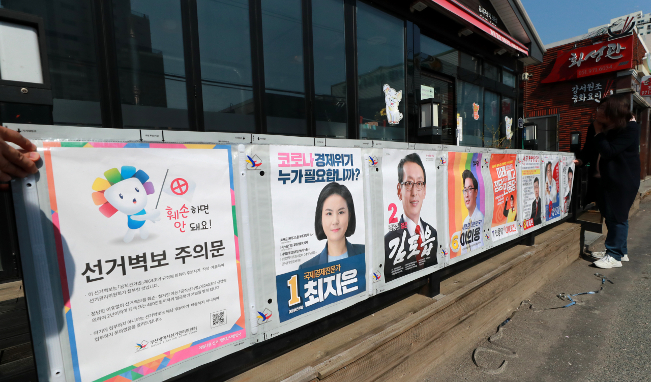 2일 부산 강서구청 인근 한 벽면에 대저1동 행정복지센터 관계자들이 선거 벽보를 부착하고 있다. [연합]