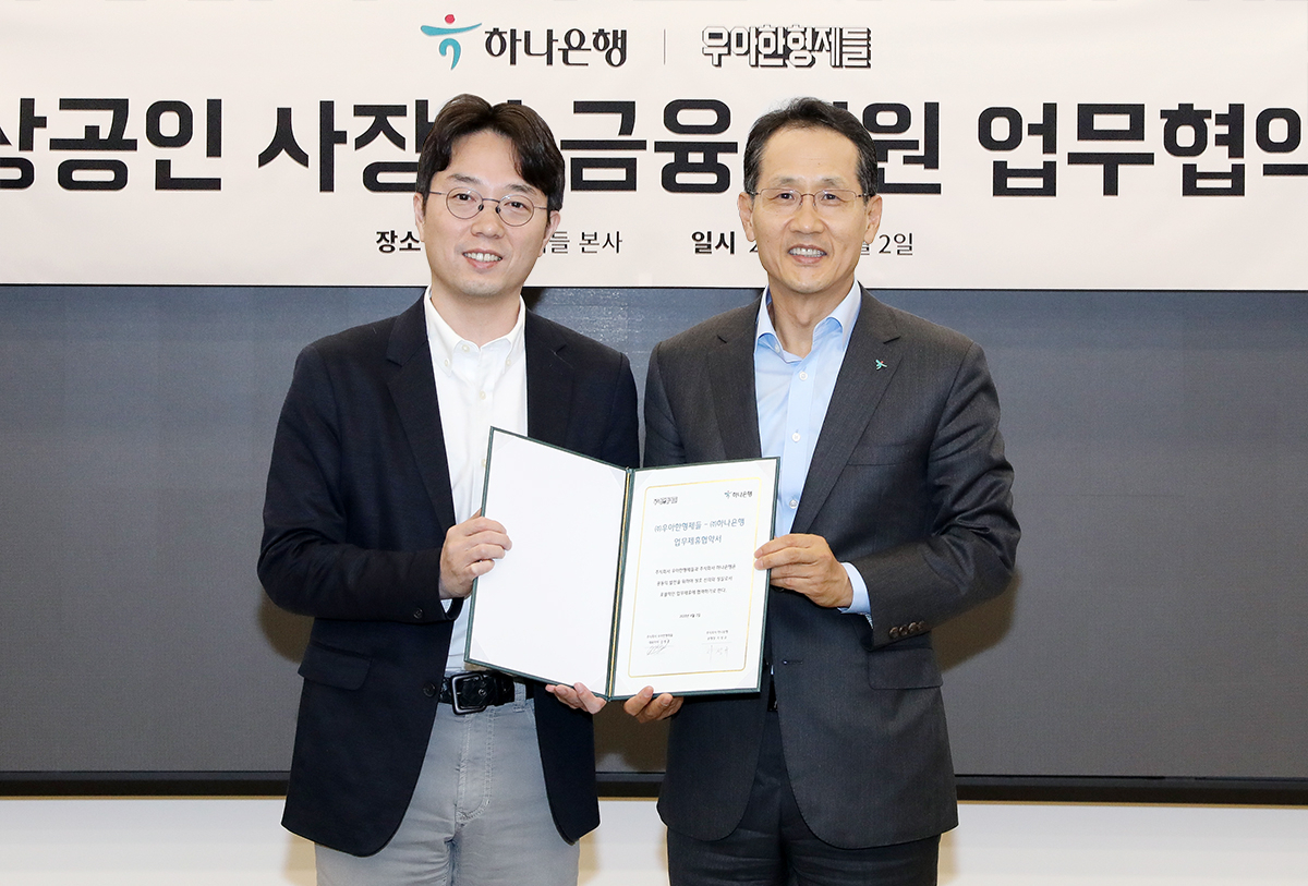 지성규 하나은행장(사진 오른쪽)과 김범준 ㈜우아한형제들 대표가 2일 서울 송파구 우아한형제들 본사에서 전략적 업무협약에 서명한 뒤 기념 촬영을 하고 있다. [하나은행 제공]