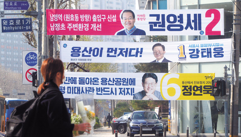 3일 오전 각 정당 용산구 국회의원 후보들의 현수막이 설치된 서울 원효로 인근에서 시민들이 길을 건너고 있다. 박해묵 기자