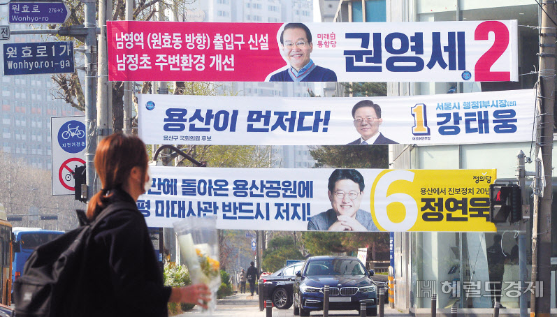 3일 오전 각 정당 용산구 국회의원 후보들의 현수막이 설치된 서울 원효로 인근에서 시민들이 길을 건너고 있다. [헤럴드경제=박해묵 기자]