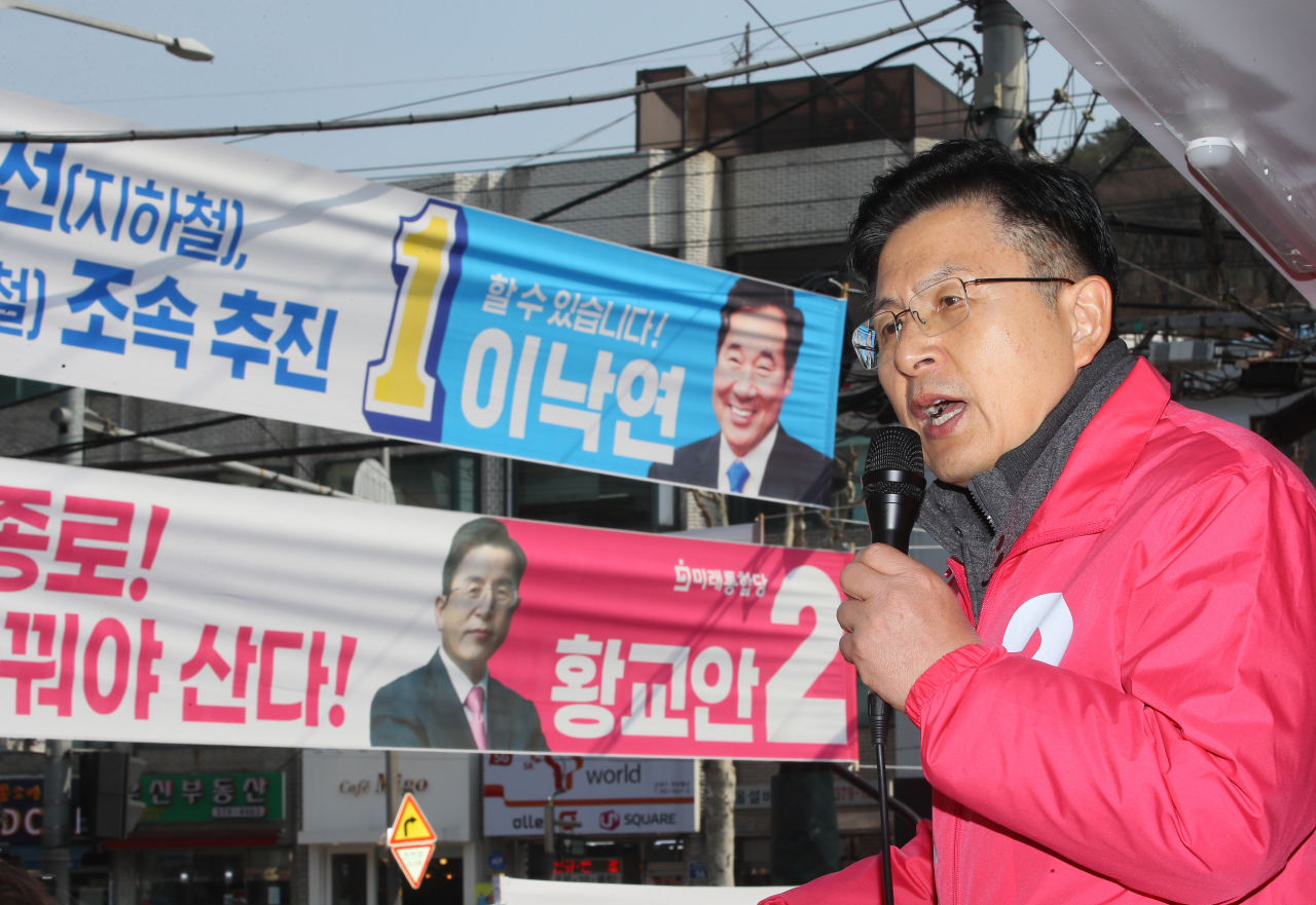 제21대 국회의원 선거운동이 시작된 2일 서울 종로구 평창동 골목에서 황교안 미래통합당 종로 후보가 더불어민주당 이낙연 후보와 자신의 현수막을 배경으로 지지를 호소하고 있다. [연합]