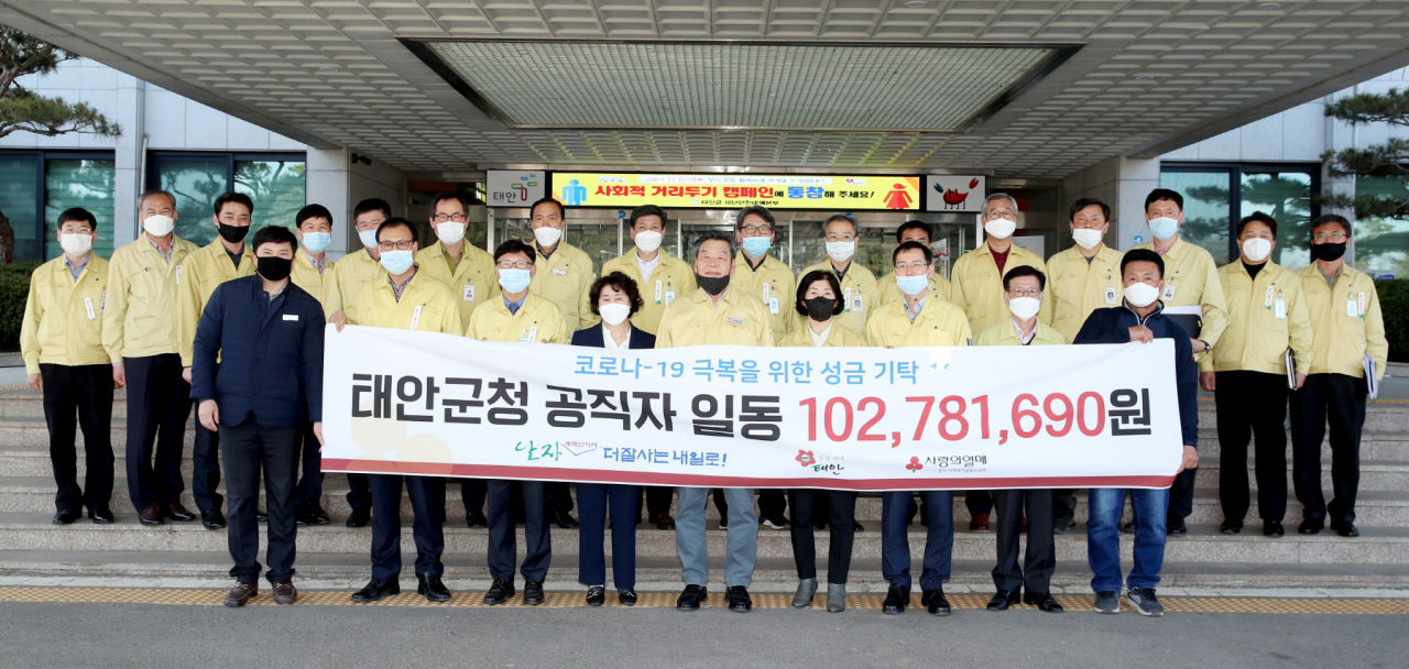 가세로 군수(앞줄 가운데)를 비롯한 충남 태안군청 공직자들이 3일 태안군청 현관 앞에서 박은희 충남사회복지공동모금회 사무처장(왼쪽 네 번째)에게 군청 직원들이 십시일반으로 모은 코로나19 극복 기금 1억278만원을 전달한 뒤 기념사진을 찍고 있다. [연합뉴스]