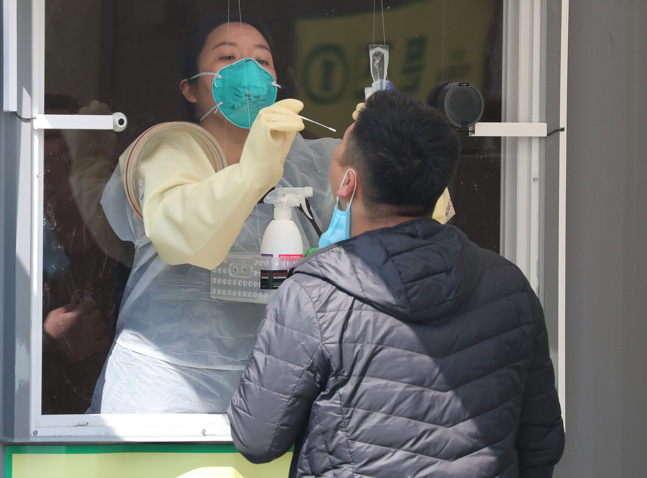 지난 3일 오후 서울 송파구 잠실종합운동장에 마련된 워크스루 방식 선별진료소에서 한 시민이 검체채취를 받고 있다. [연합]