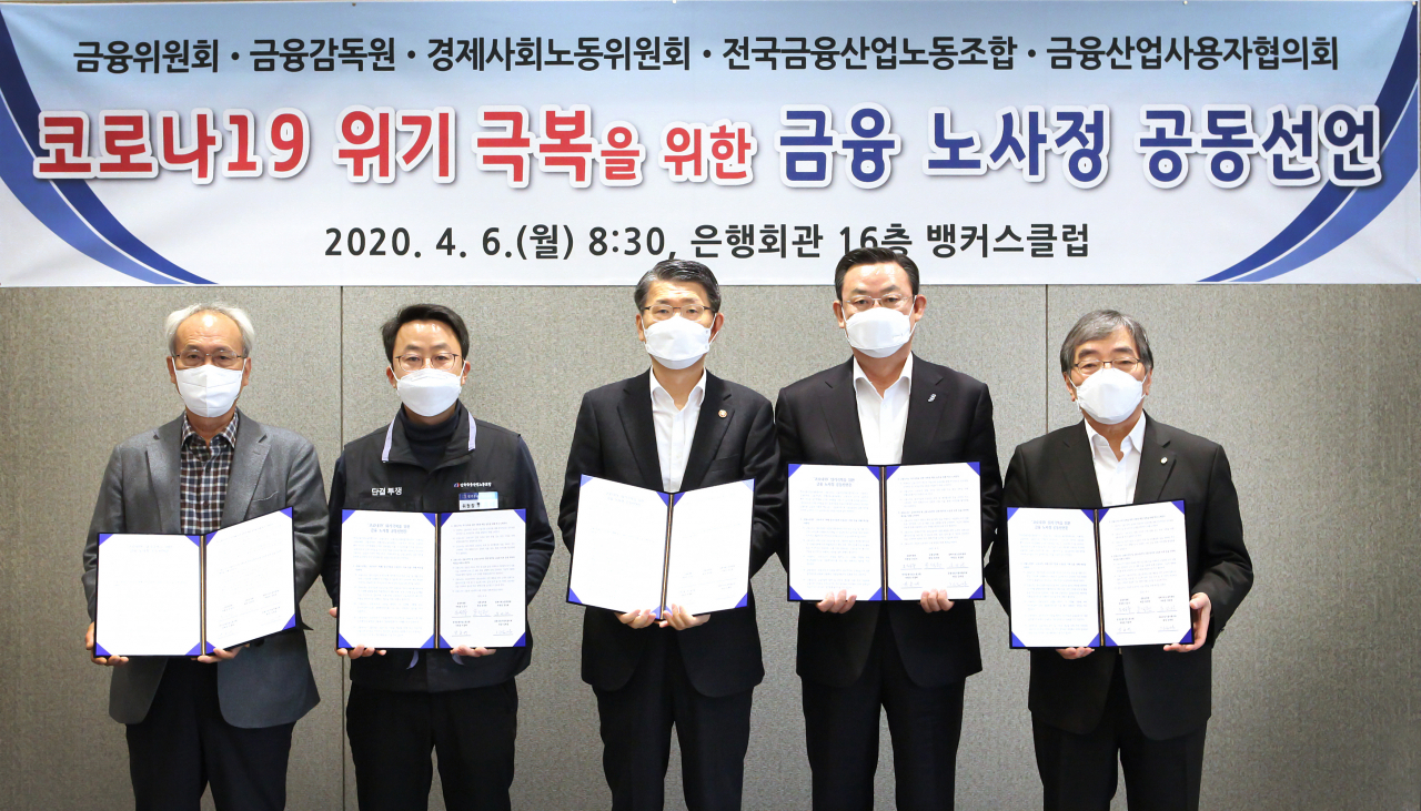 문성현(왼쪽부터) 경제사회노동위원회 위원장, 박흥배 전국금융산업노동조합 위원장, 은성수 금융위원회 위원장, 김태영 금융산업사용자협의회 회장(은행연합회장), 윤석헌 금융감독원 원장이 6일 서울 명동 은행회관에서 코로나19 위기 극복을 위한 금융 노사정 공동선언문에 서명한 후 기념촬영을 하고 있다. [은행연합회 제공]