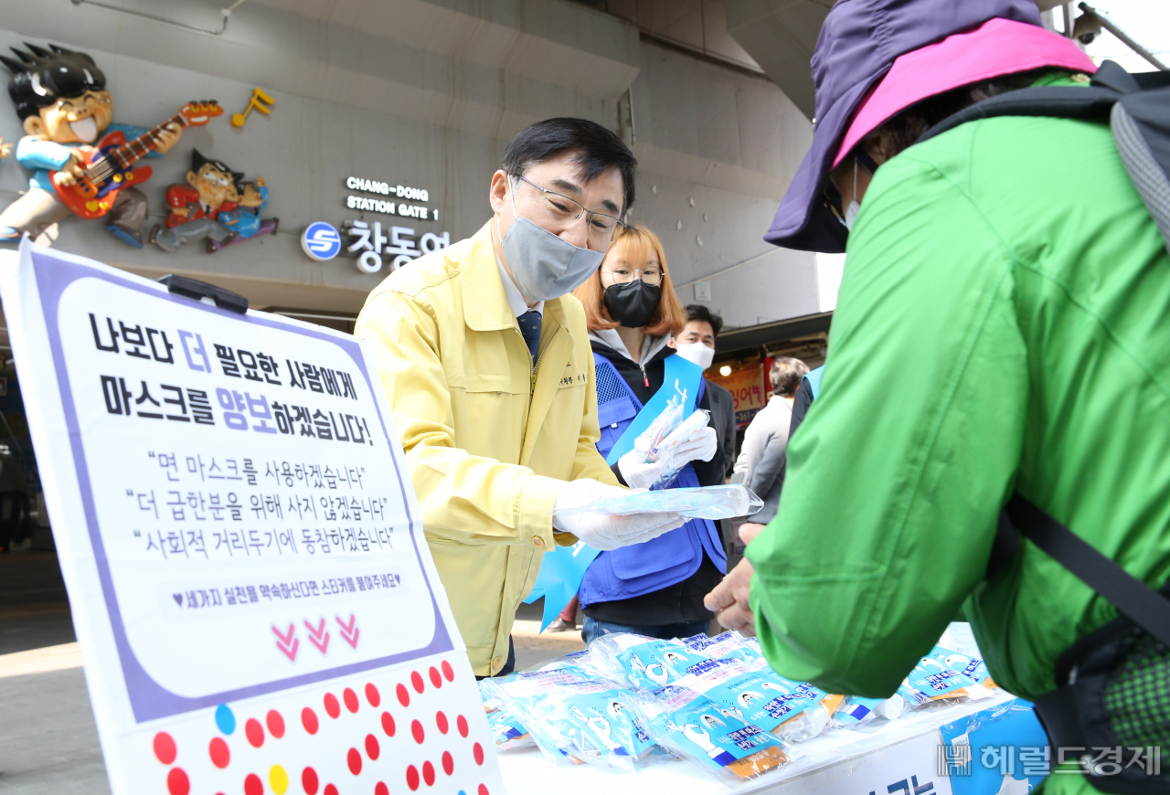 이동진 도봉구청장(왼쪽)이 주민들이 보건용마스크를 기부하면 면마스크로 교환해 주고 있다. [도봉구]