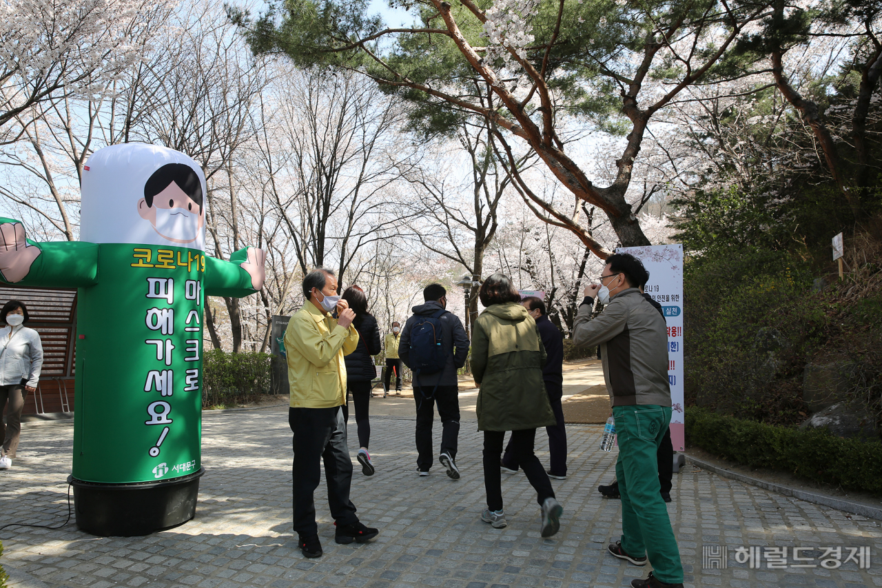 지난 주말 서대문구청 직원들이 안산 연희숲속쉼터 부근에서 산책 나온 시민들에게 마스크 착용과 사회적 거리두기를 안내하고 있다. 서대문구는 시민들에게 마스크 착용을 강조하기 위해 이색 설치물을 세우고 마스크 착용 캠페인을 벌여 이 눈길을 끌었다. 구는 주말에 나들이객이 몰리는 것을 방지하기 위해 안산(鞍山) 진입 차량을 통제했다. [서대문구]
