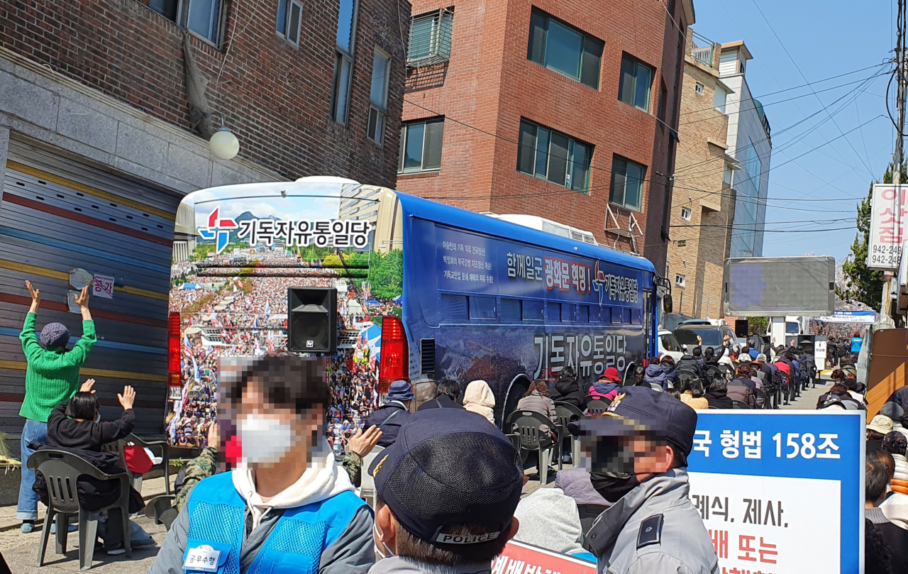 지난 5일 오전 현장 예배를 강행한 서울 성북구 사랑제일교회 예배당에 들어가지 못한 신도들이 근처 골목에서 예배를 드리고 있다. 연합뉴스