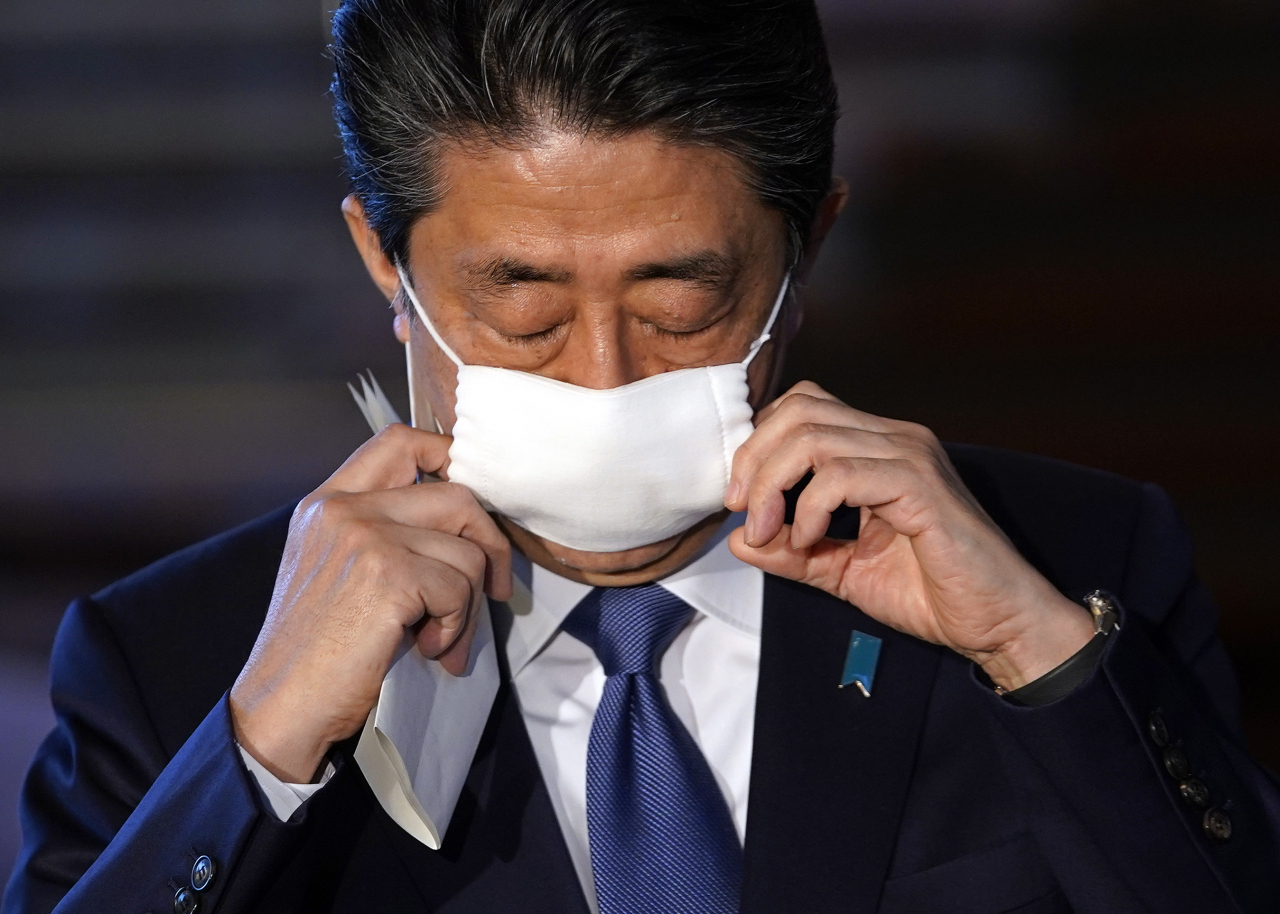 아베 신조(安倍晋三) 일본 총리가 6일 일본 도쿄 총리 공관에서 기자회견을 위해 안면 마스크를 벗고 있다. [EPA]