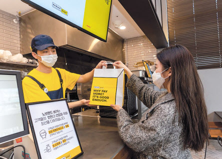 노브랜드버거 매장에서 제품을 포장해가는 모습 [신세계푸드 제공]