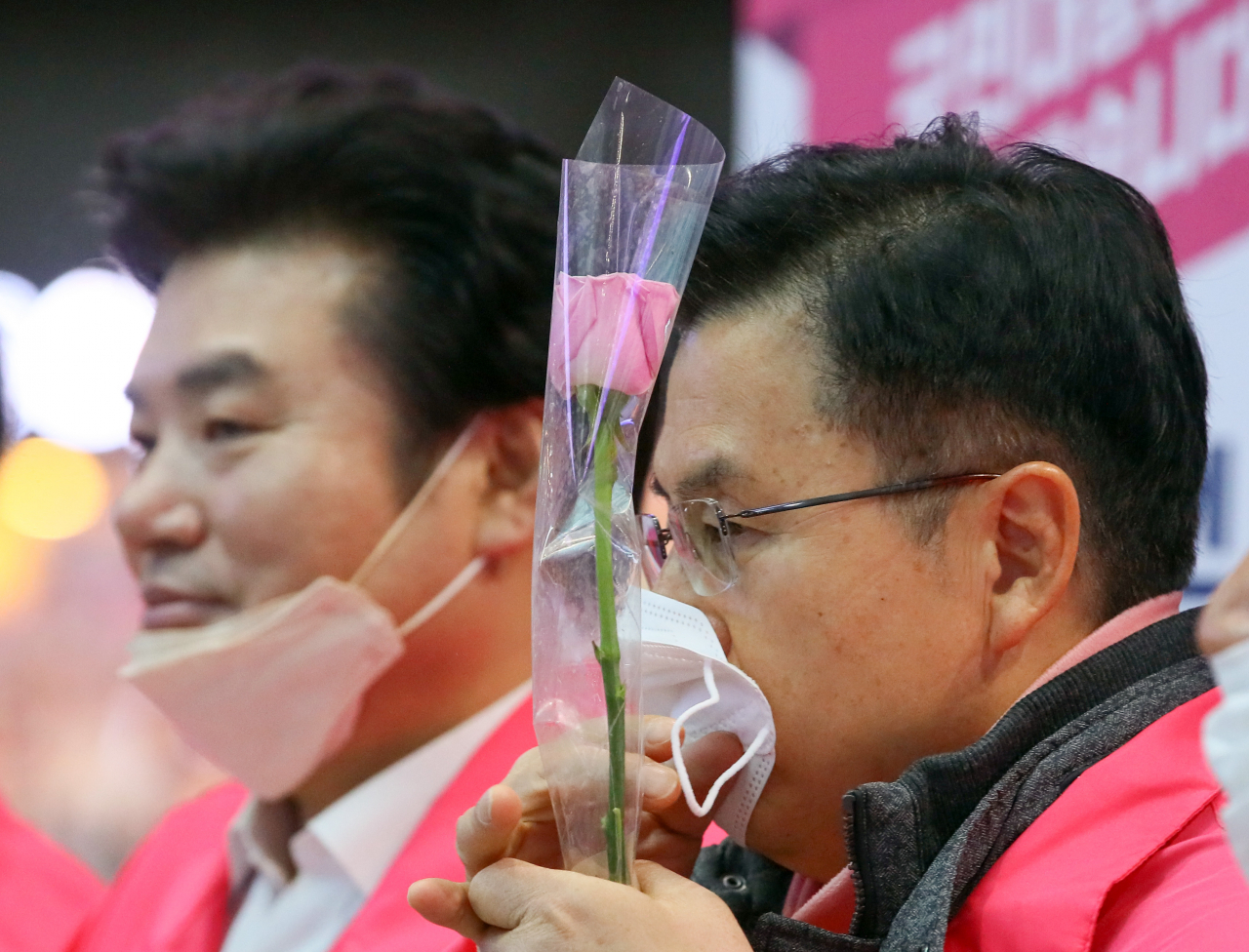 황교안 미래통합당 대표 및 총괄선대위원장이 7일 서울 용산역에서 광주 5·18묘역 등 호남을 방문하는 비례위성자매정당 미래한국당의 원유철 대표 및 비례대표 후보들을 배웅하며 선물받은 핑크 장미를 들고 있다. [연합]