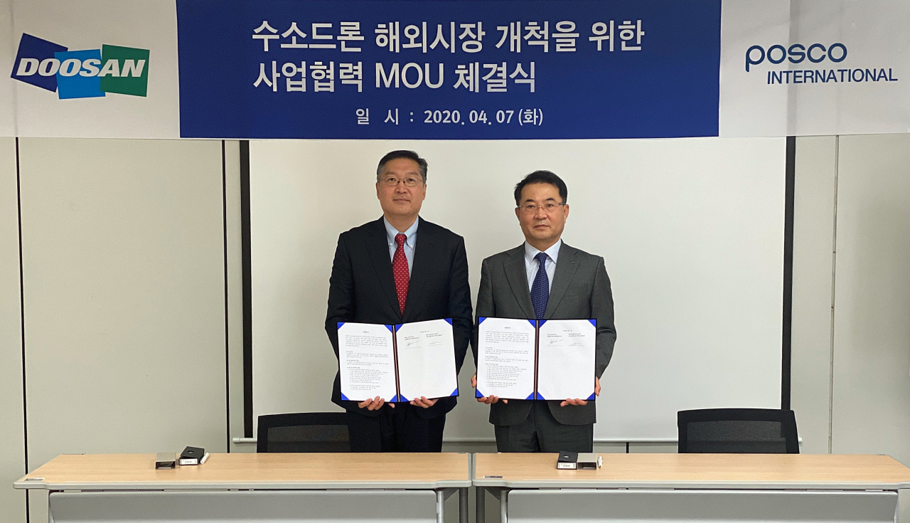 7일 경기도 용인 두산모빌리티이노베이션(DMI) 본사에서 이두순(왼쪽) DMI 대표와 유재진 포스코인터내셔널 자동차사업실장이 수소드론의 해외사업 공동추진을 위한 업무협약서를 들고 기념촬영을 하고 있다. /사진제공=DMI