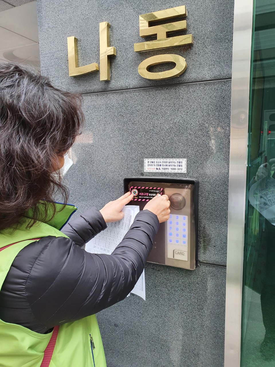 서초방역단이 건물 현관 인터폰에 바이러스 항균필름을 부착하고 있다. [서초구 제공]