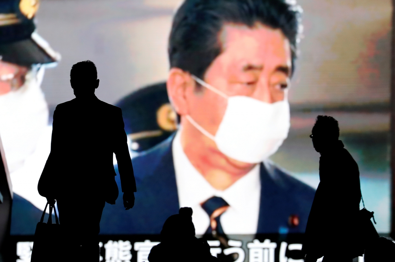 아베 신조(安倍晋三) 일본 총리는 최근 수도권을 중심으로 확산되는 신종 코로나바이러스 감염증(코로나19) 사태에 대한 대응으로 8일부터 한 달간 도쿄도(東京都) 와 오사카부(大阪府) 등 주요 7개 지역에 대해 긴급사태를 발동했다. 한편 이날 중국 후베이성 정부는 코로나19 진원지이자 최대 피해지역인 우한시에 내려진 봉쇄령을 발령 76일만에 해제했다. 사진은 7일 아베 총리의 모습이 나오는 도쿄의 한 전광판 앞을 시민들이 지나가고 있는 모습. [로이터]