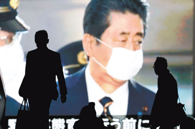 아베 신조(安倍晋三) 일본 총리는 최근 수도권을 중심으로 확산되는 신종 코로나바이러스 감염증(코로나19) 사태에 대한 대응으로 8일부터 한 달간 도쿄도(東京都) 와 오사카부(大阪府) 등 주요 7개 지역에 대해 긴급사태를 7일 발동했다. 사진은 이날 아베 총리의 모습이 나오는 도쿄의 한 전광판 앞을 시민이 지나가고 있는 모습. [로이터]